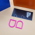 Pink archway shaped 3D printed earrings on a beige background with black branded backing card.
