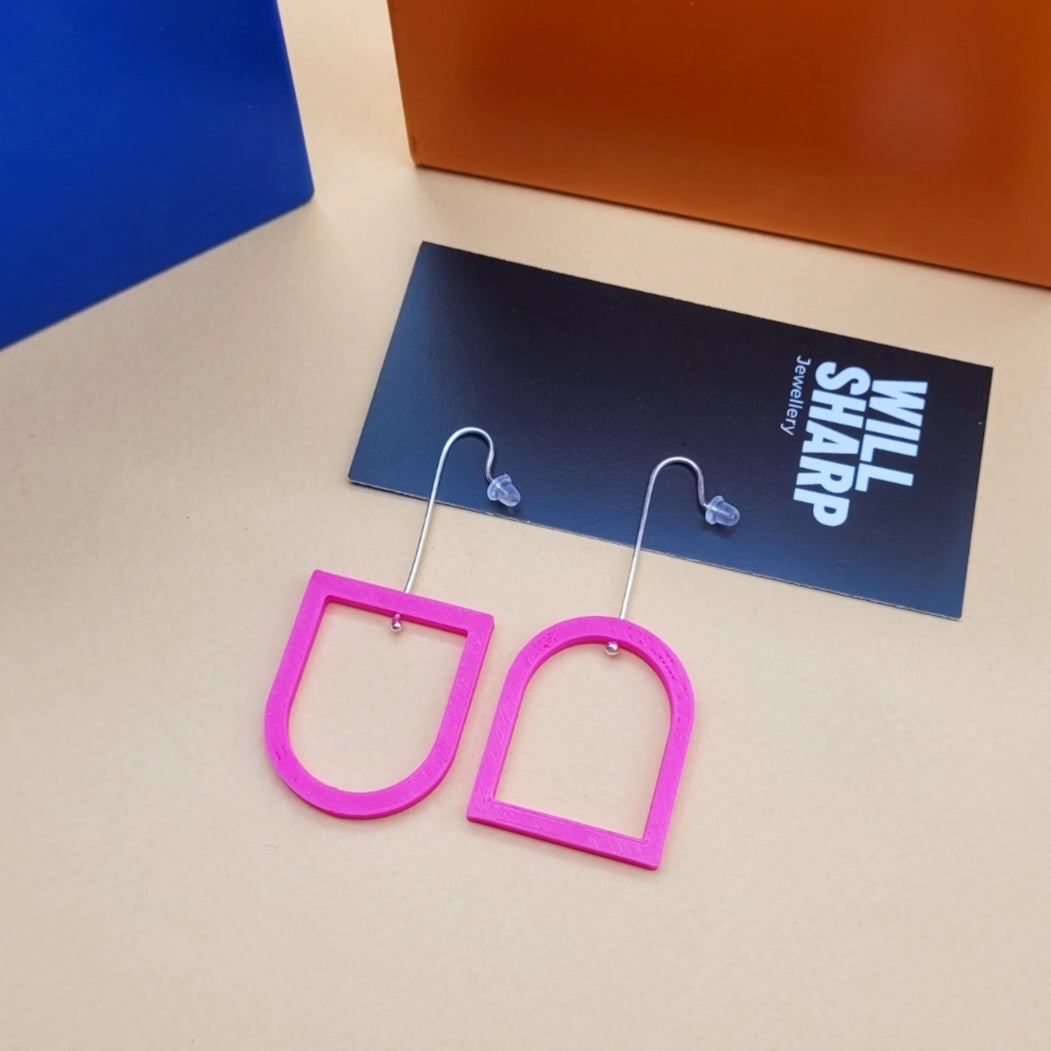 Pink archway shaped 3D printed earrings on a beige background with black branded backing card.