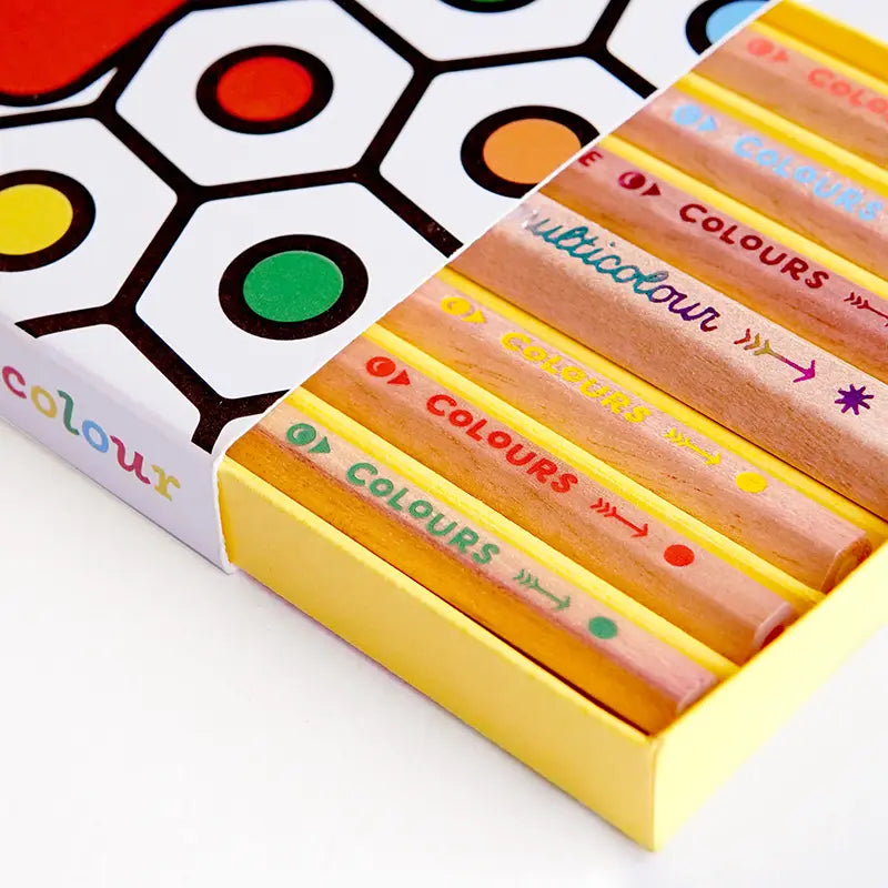 Set of multicolored crayons in a box with a colour chart on a white background