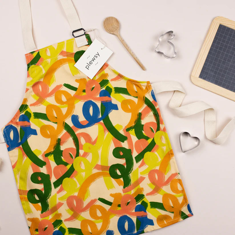 Kids apron with squiggle pattern, laid flat on a surface