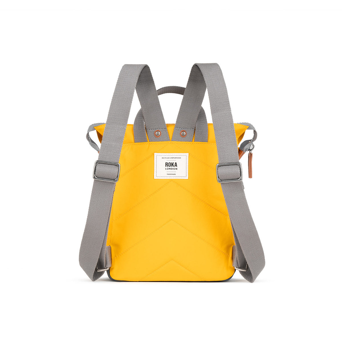 A yellow backpack with grey straps. The backpack has a roll-top closure and a ROKA London logo on the back.