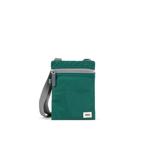 Small crossbody bag by ROKA in teal colour - white background.