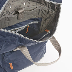 Details of navy Blue rucksack by ROKA photographed with white background.