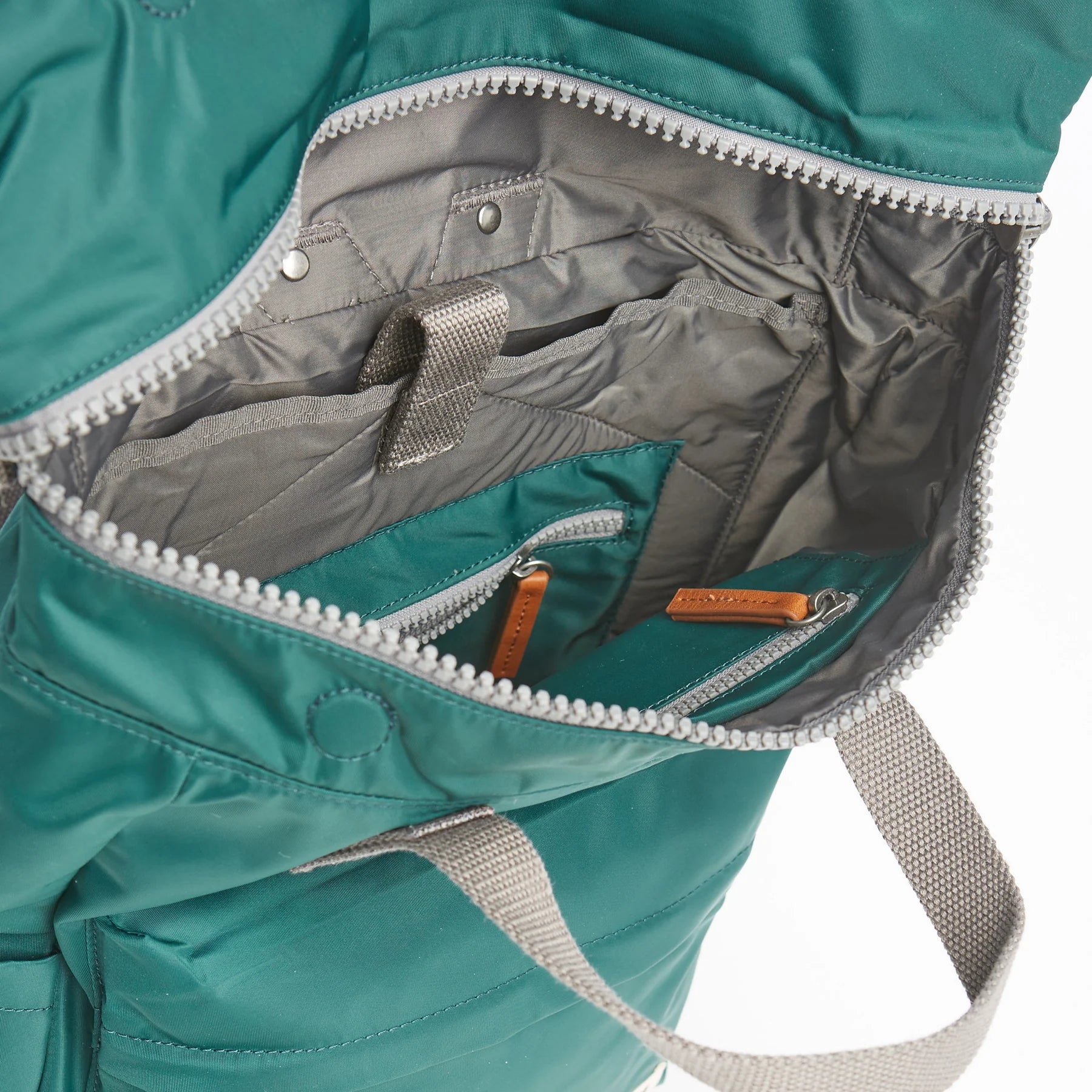 Detail of a teal rucksack by ROKA photographed with white background.