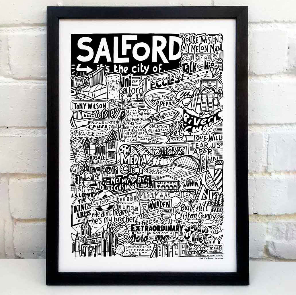 A black and white illustration celebrating Salford's cultural landmarks and music scene, featuring iconic venues, band names, and local references. Placed in a black frame in front of a white wall.