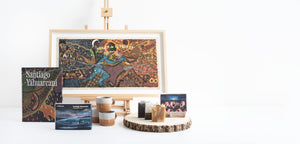 Selection of products including print, soaps and candles presented in front of a white backdrop.