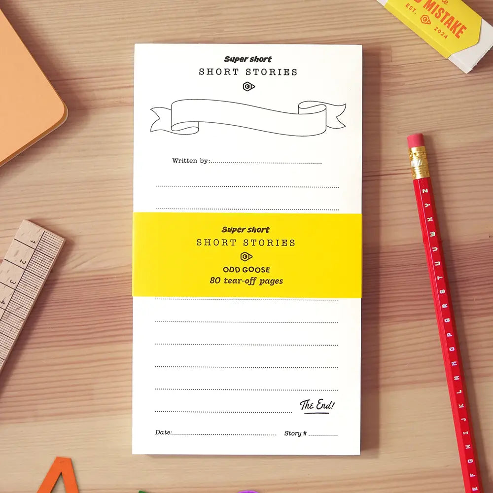 Tear off notepad on a wooden desk surface with stationery surrounding it