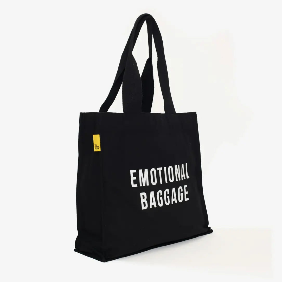 Black tote bag with 'EMOTIONAL BAGGAGE' text on a white background