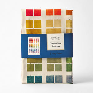 Roomy Town Watercolor Swatch Tea Towel, a 100% cotton tea towel folded and packaged with a blue label. The tea towel features a grid of watercolour swatches in various colours.