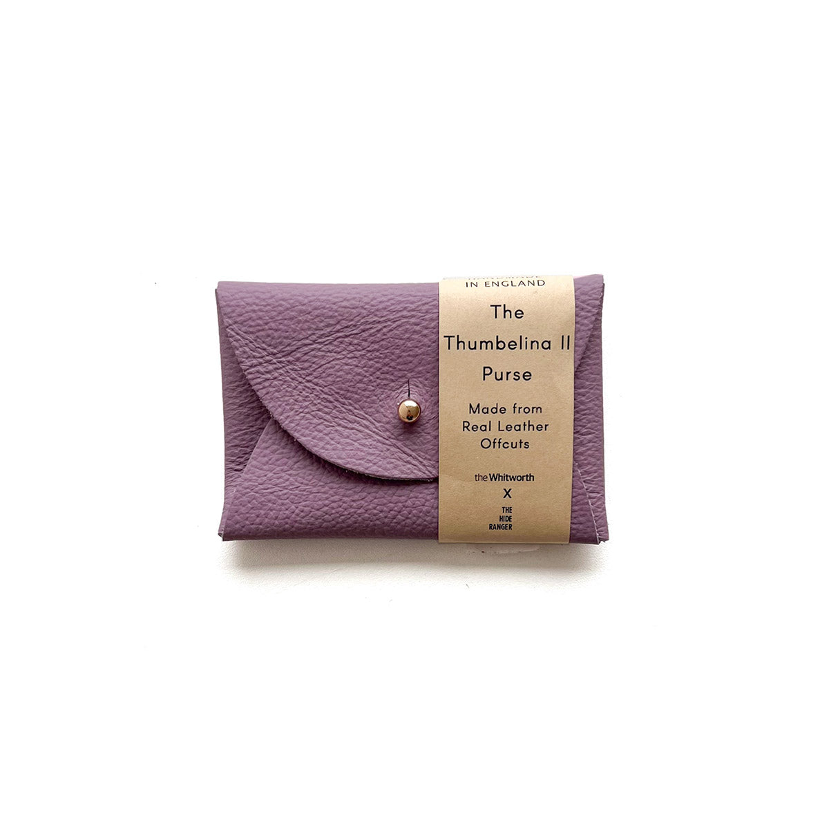 Rectangular lilac leather purse with silver button, presented on a white background with a branded paper bellyband across the right hand side.