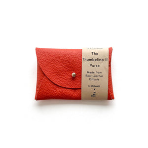 Rectangular dark orange leather purse with silver button, presented on a white background