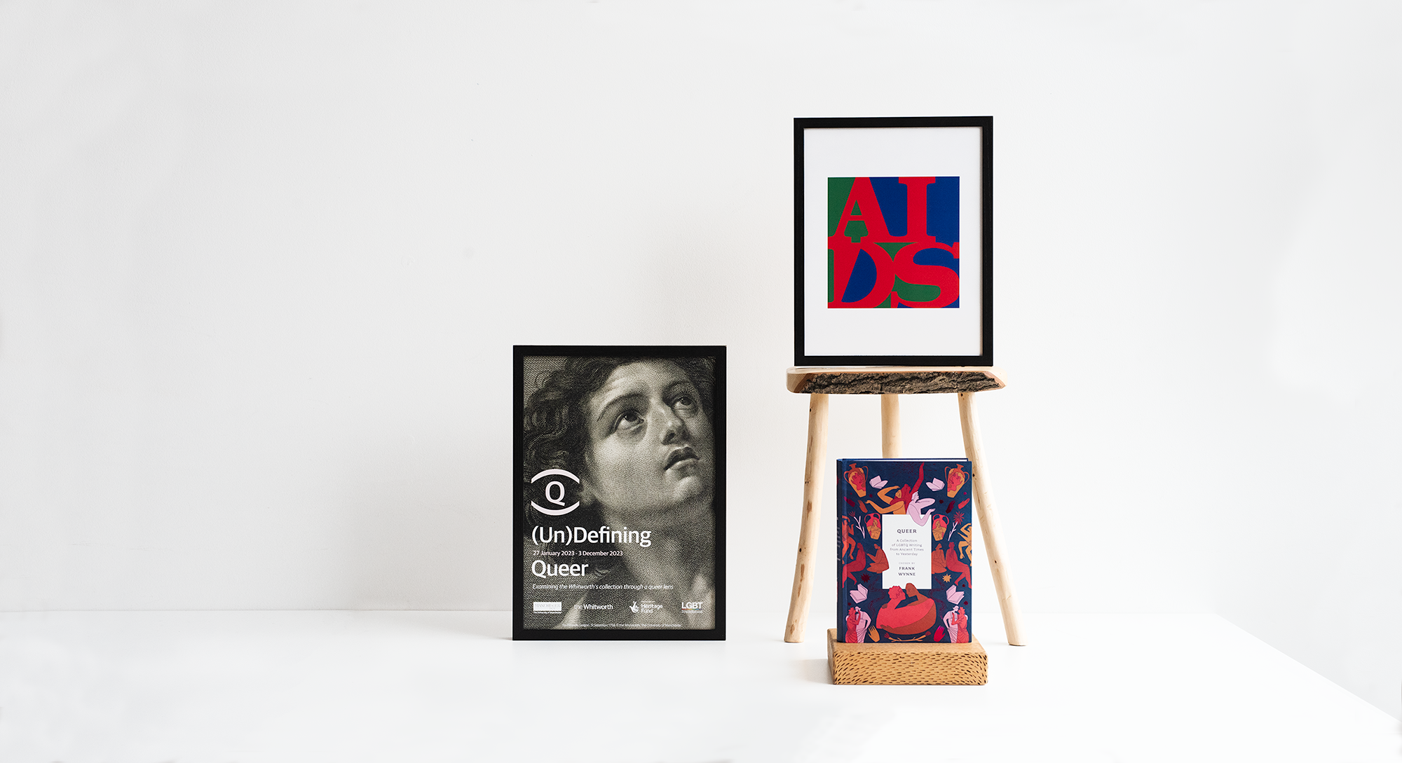 Image of 2 prints form the UnDefining Qeer collection. Also a LGBT book. White background.