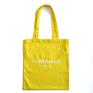 Yellow coloured tote bag with Whitworth logo against white background.