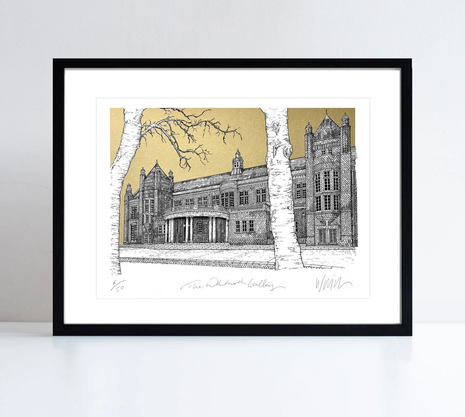 A print in a black framed. The print is a detailed line drawing of the Whitworth, set against a gold background with a tree in the foreground. 