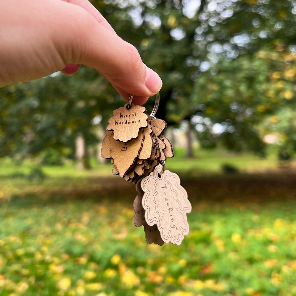 Keychain with wooden tags held by a hand against a blurred natural background