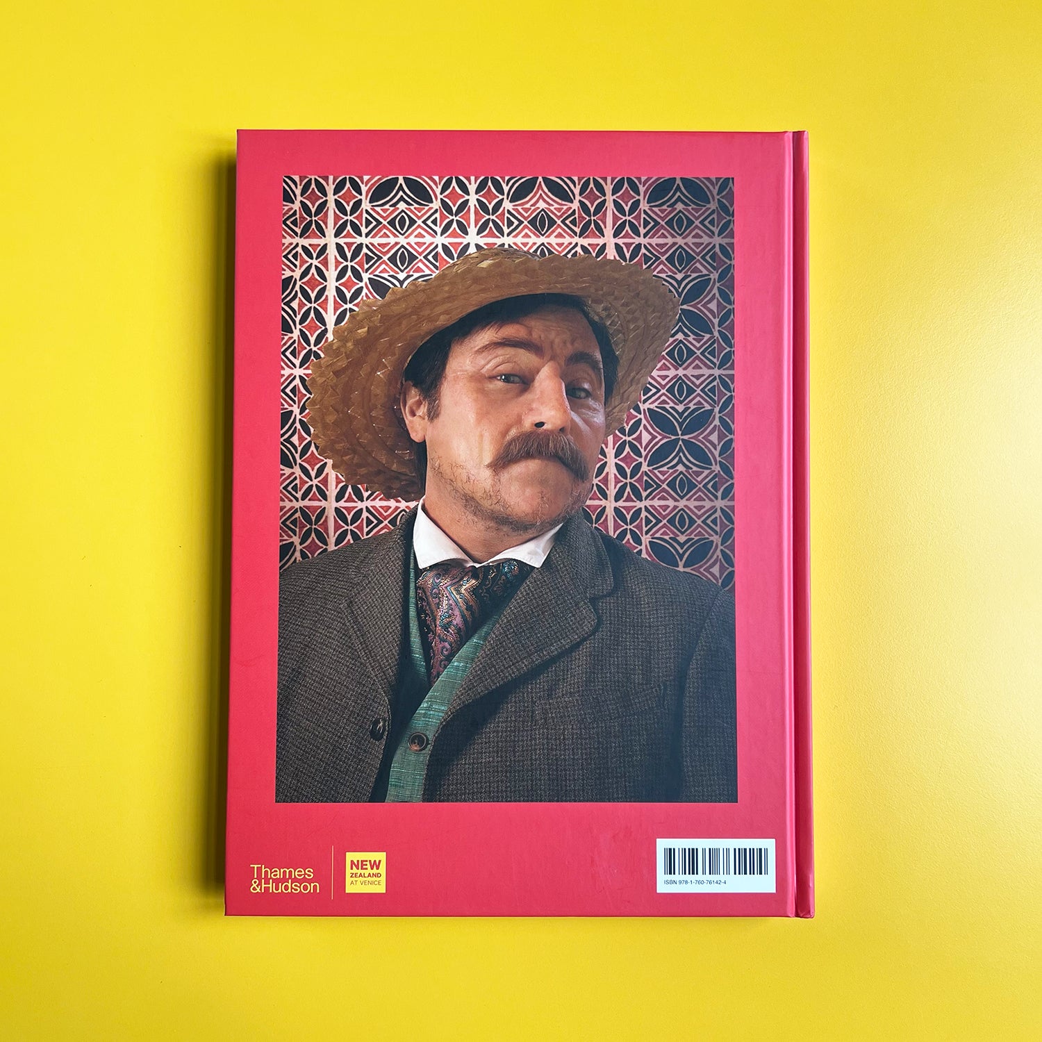 Book cover with a person in a suit and hat on a yellow background