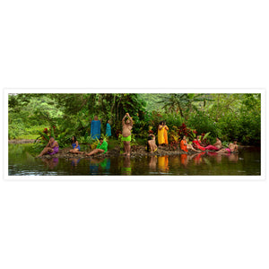 Group of people in colourful outfits by a river with lush greenery in the background
