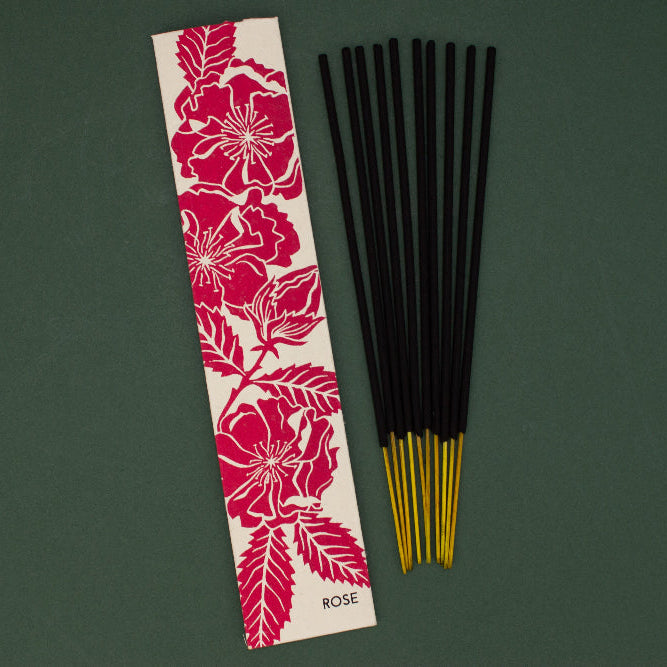 Incense sticks with a decorative packaging label on a green background