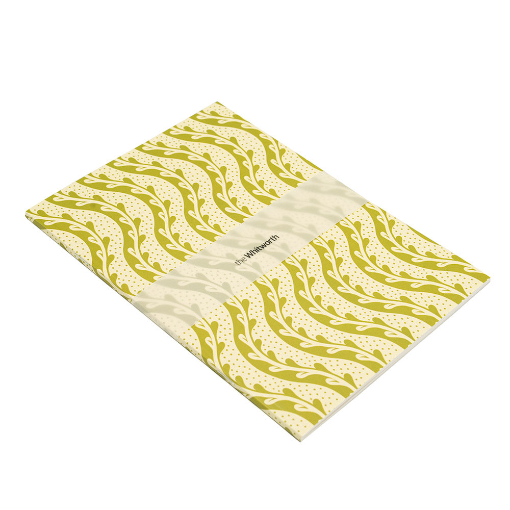 Folded notebook with green leaf pattern on a white background