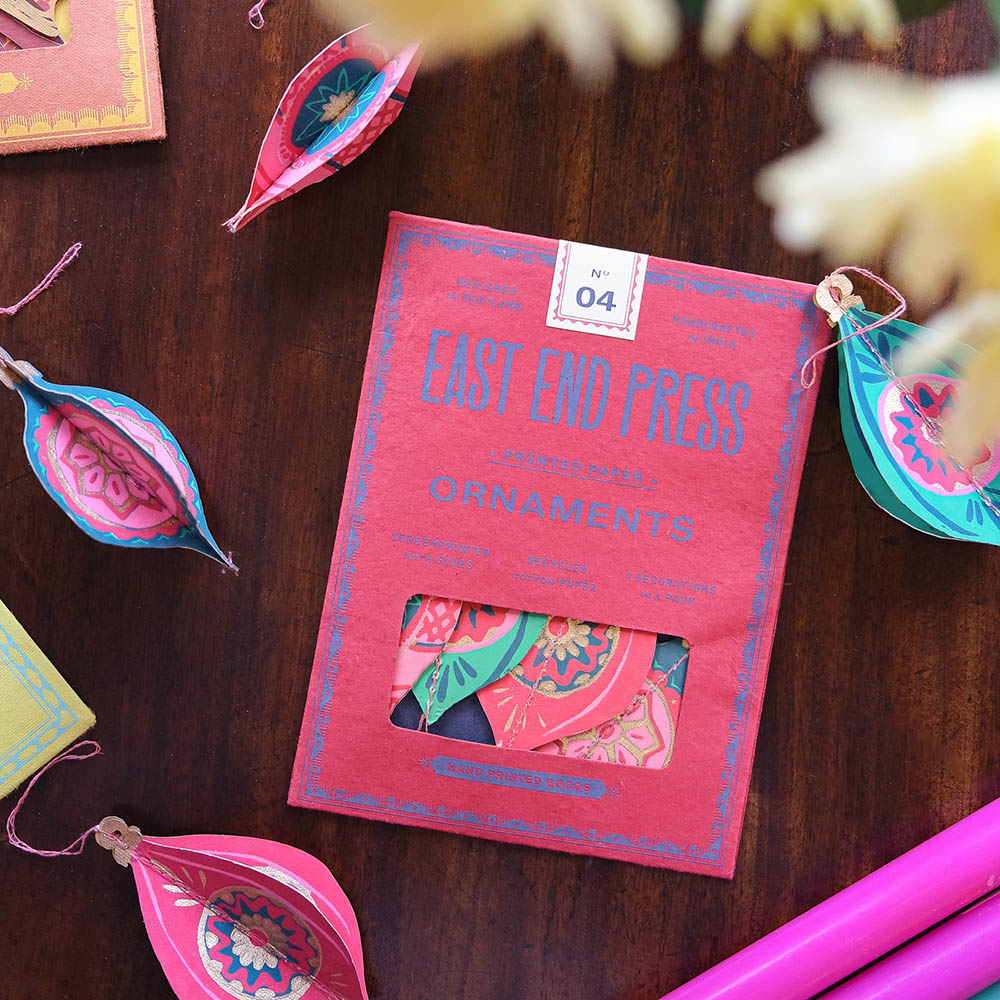 East end press packaging for paper ornament decorations, surrounded by the ornaments.