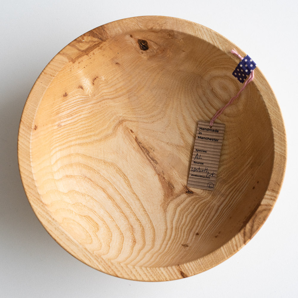 Wooden bowl with a visible brand tag on a white background