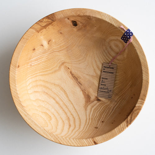Wooden bowl with a visible brand tag on a white background