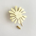 Brass pin in a seaweed sheep against a white background.