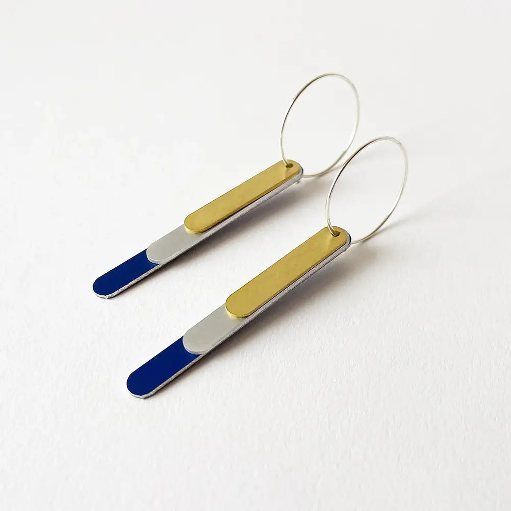Pair of earrings with gold, blue, and silver bars on a white background