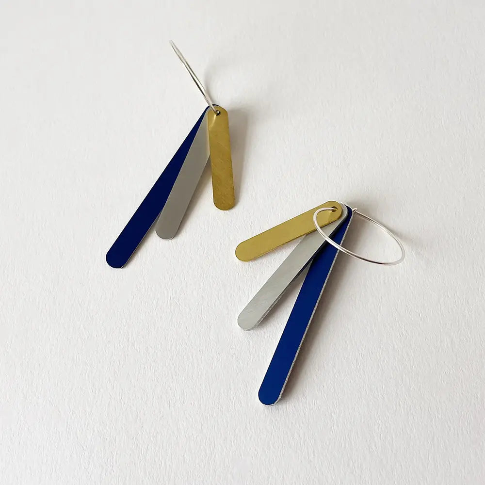 Pair of earrings with gold, blue, and silver bars on a white background