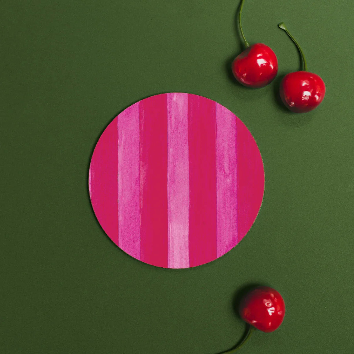 Red and pink striped coaster against a green background