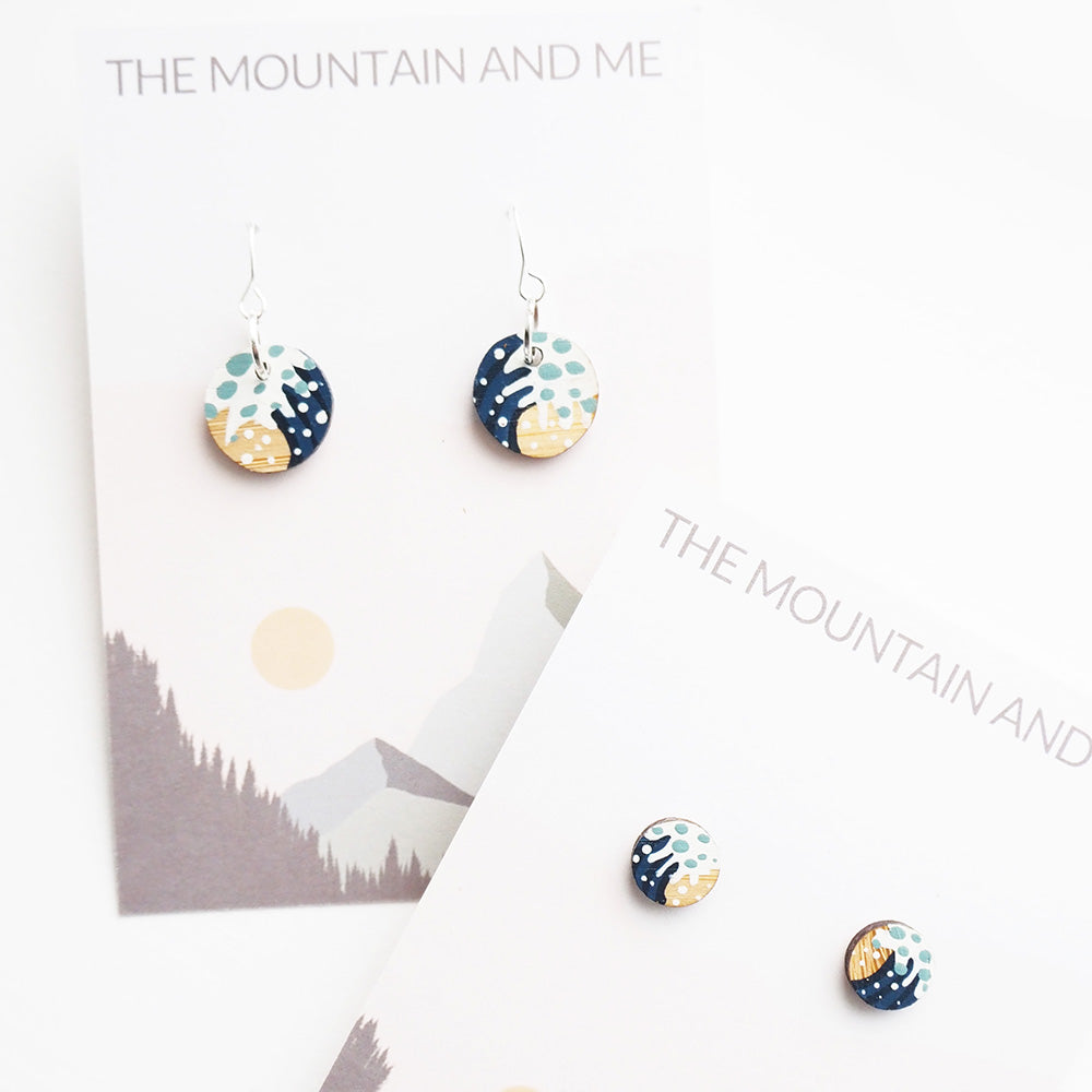 Earrings with wave design on a card featuring 'The Mountain and Me' branding.