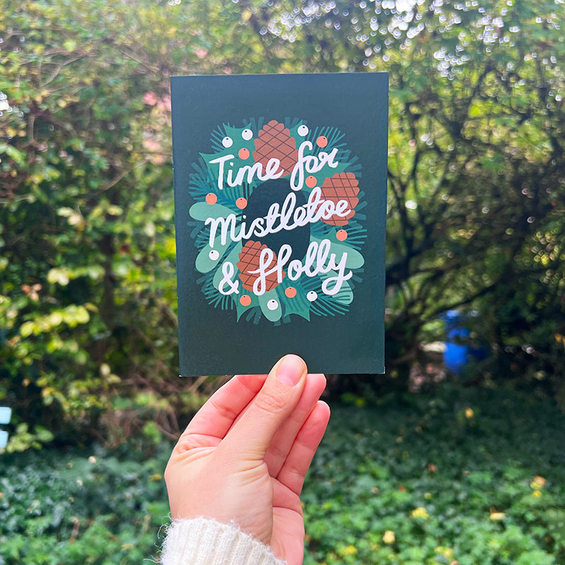 Greetings card with 'Time for mistletoe and Holly' a the centre