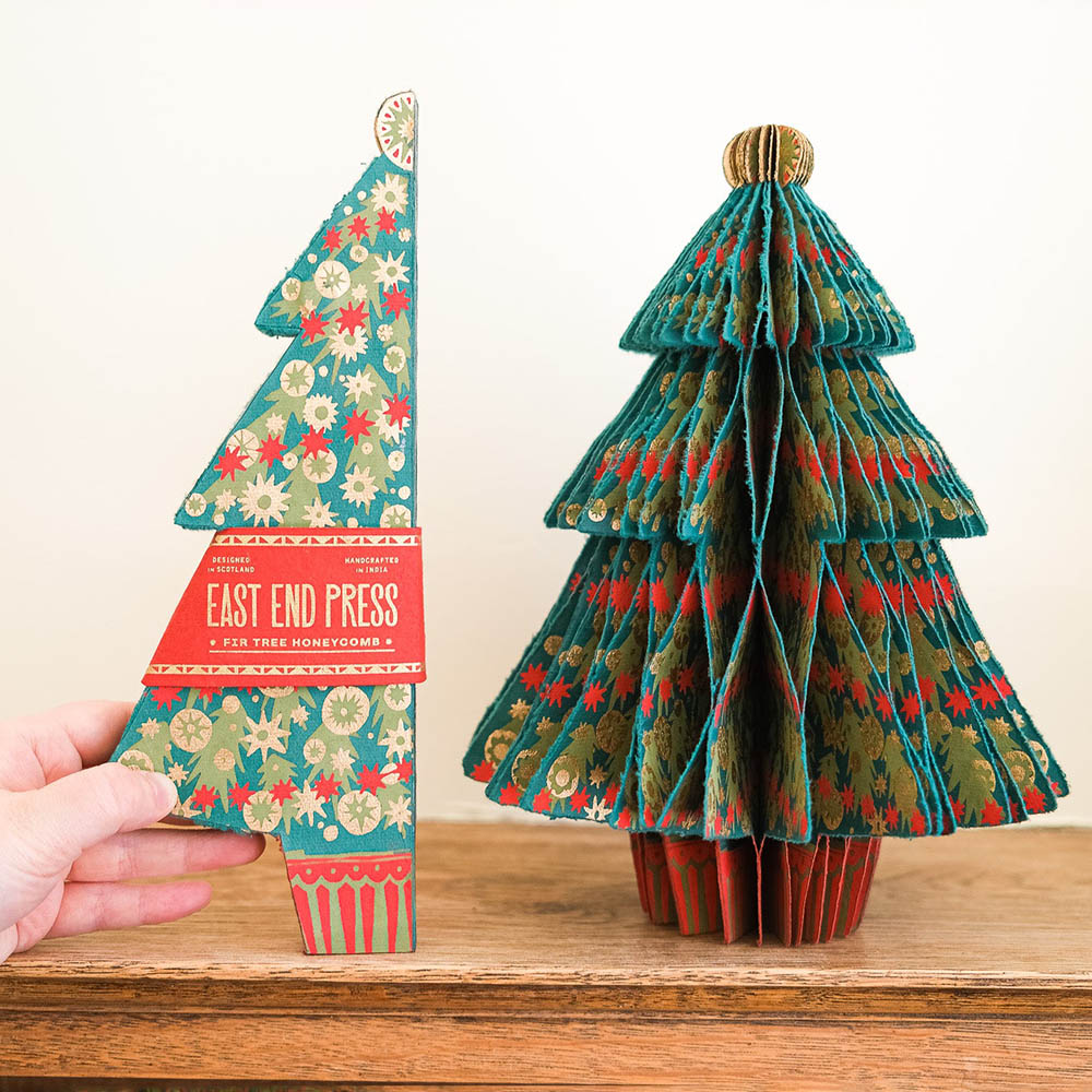Decorative paper Christmas tree with floral design on a wooden surface