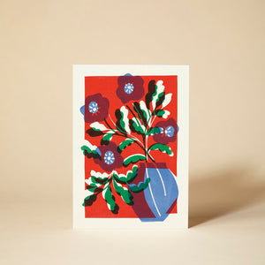 Greetings card with red, yellow, blue and white silhouette floral design.