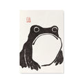 A Japanese woodblock art print featuring a black ink frog illustration on an off-white textured paper background, with a small red seal in the upper left corner.