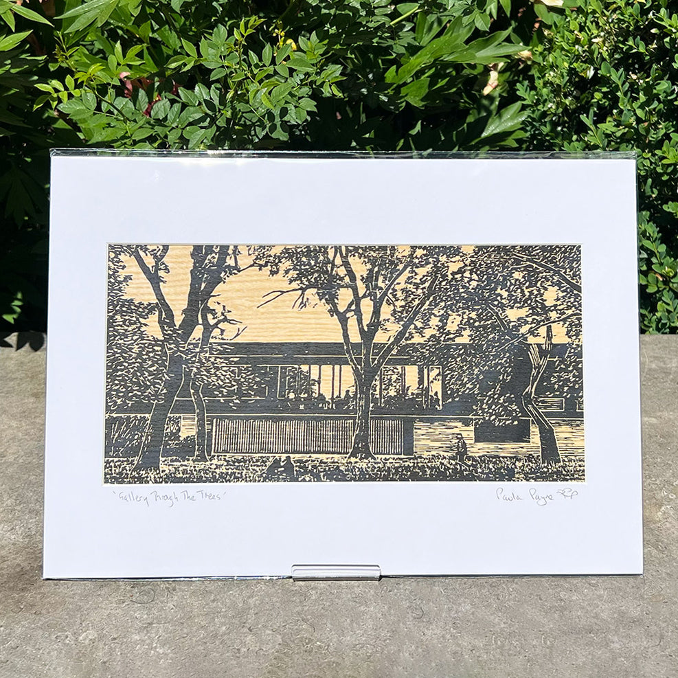 Linocut print featuring the Whitworth Cafe - presented upright in front of some green foliage