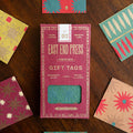 East End Press pink packaging for gift tags on a table with the gift tags surrounding it