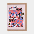 This is a white greetings card with a drawing of two pink cats with blue flower-like spots and yellow stars around them.
