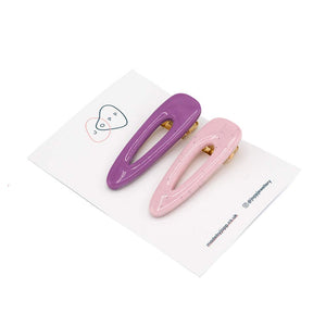 Pink and purple polymer clay hair clips photographed on white backing card with Jopp branding. White background.