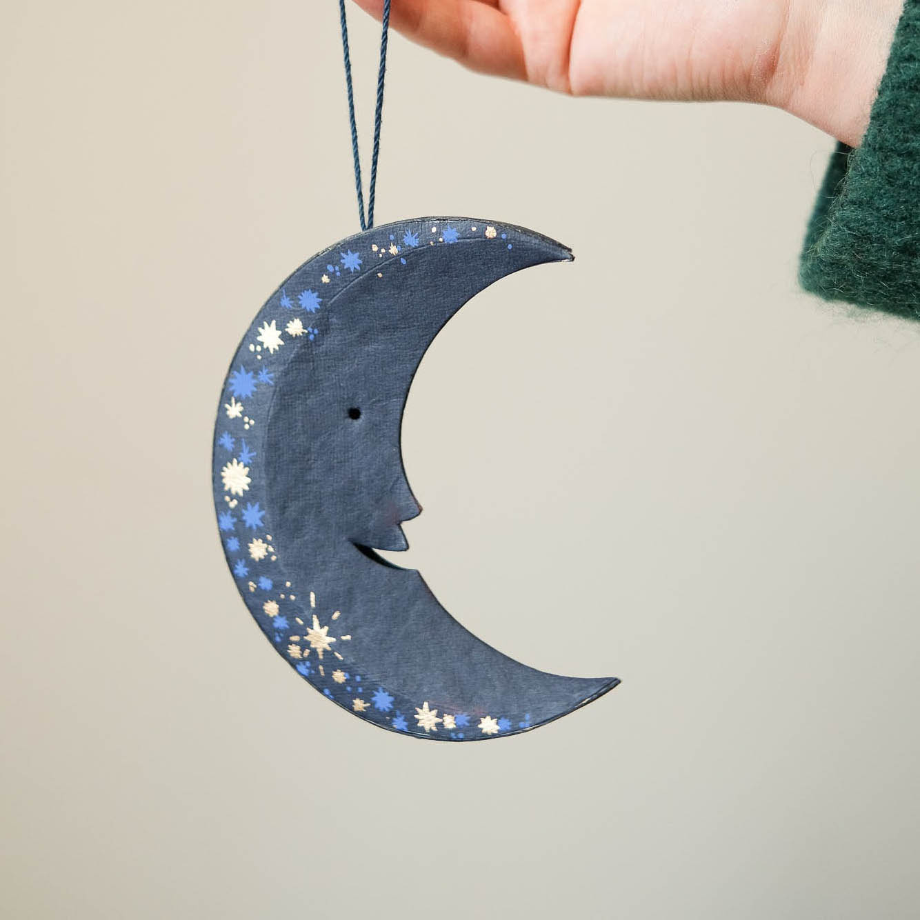 Decorative moon-shaped ornament with star patterns on a beige background