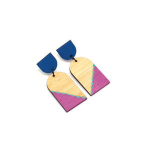 Dangly earrings photographed against white background. The earrings are each in two pieces, the top is a navy semi-circle and the bottom is an arch shape with pink and blue pattern.