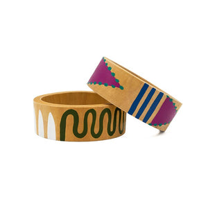 Two handed painted wooden bangles, one resting on top of the other. Each have interesting graphic painted design in colours white and green, and pink and blue.