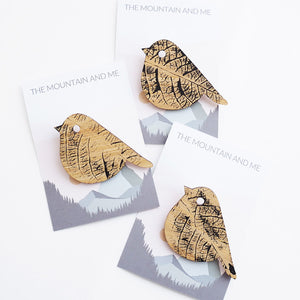 Three wooden brooch in the shape of a bird against The Mountain and Me branded backing cards