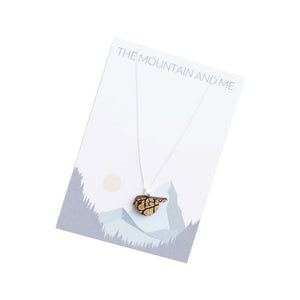 Wooden bird pendant on a silver chain presented against Mountain and Me backing card