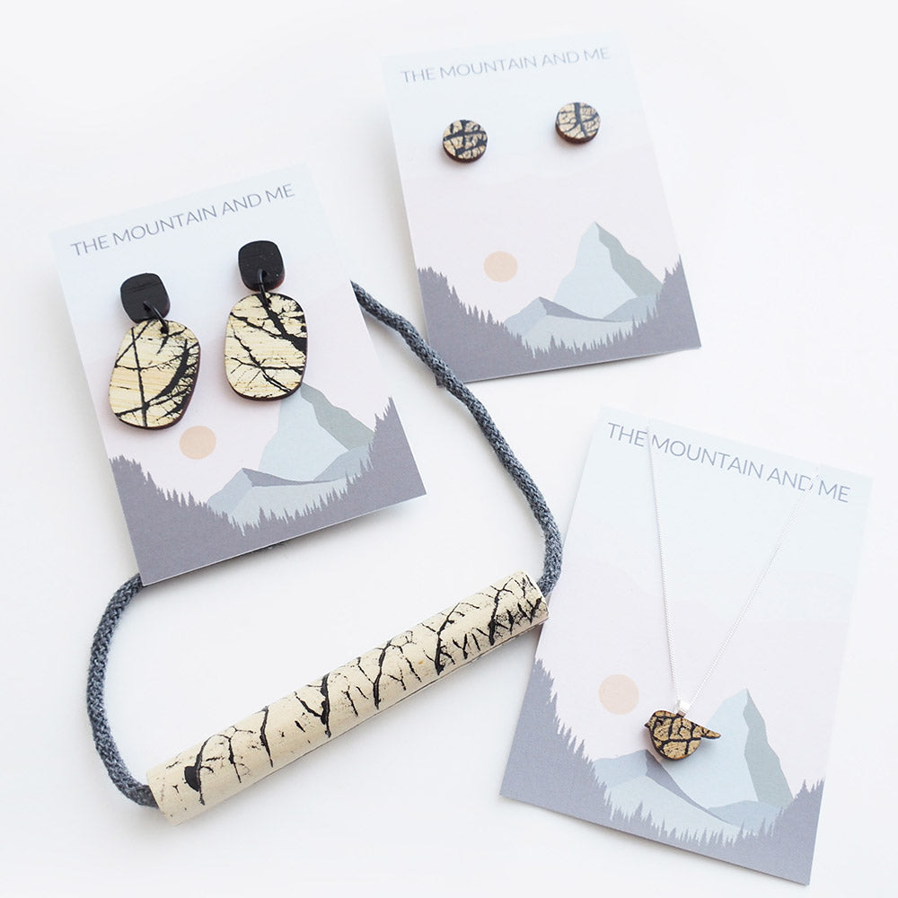 Selection of wooden jewellery placed on The Mountain and Me branded backing card