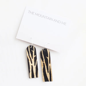 Dangly earrings against a white backdrop 