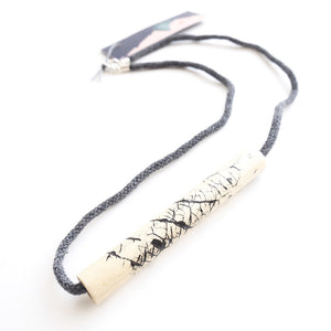 Tube wooden necklace against a white backdrop