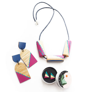 A collection of wooden hand-painted jewellery in pink and blue tones.