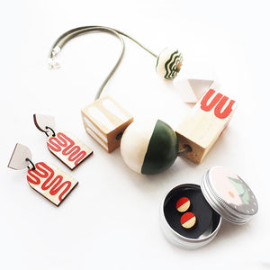A selection of chunky jewellery which is hand-painted in orange and green geometric shapes.