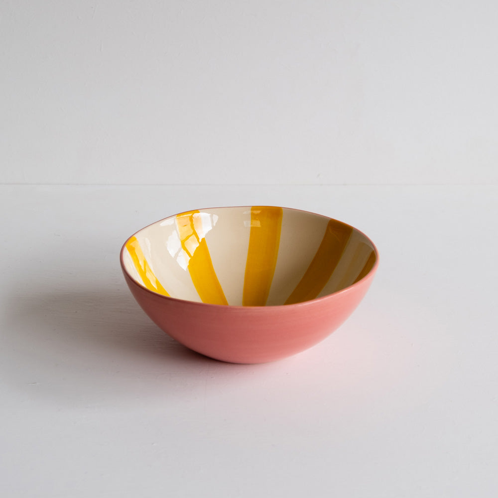 Ceramic bowl with yellow candy stripe on the inside and on the outside it's painted pink